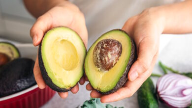Femeie care tine in maini doua jumatati de avocado pentru dieta