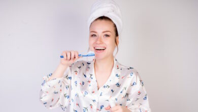 Femeie care zambeste si se spala pe dinti